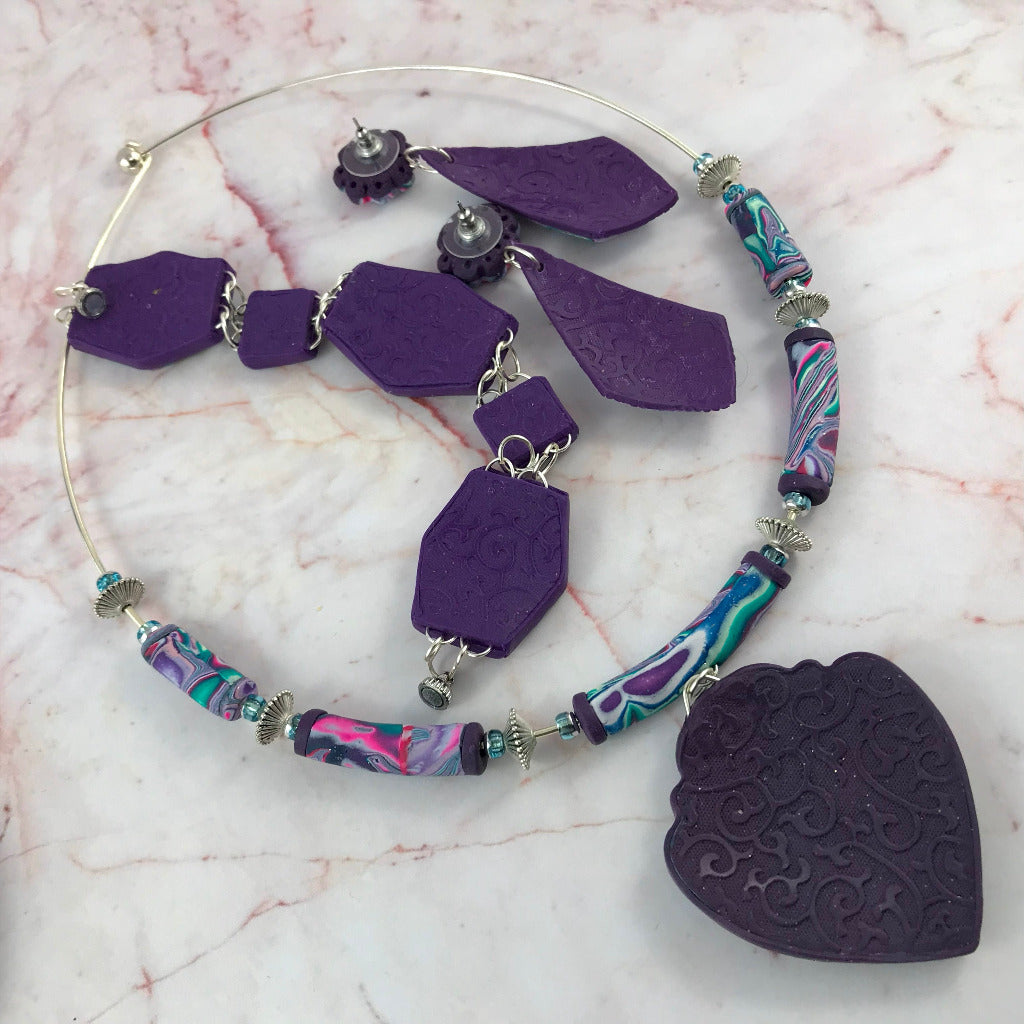 Back view of handmade Cosmic Flower changeable jewellery set showing textured purple polymer clay finish on heart pendant, bracelet and matching earrings, artisan jewellery Australia