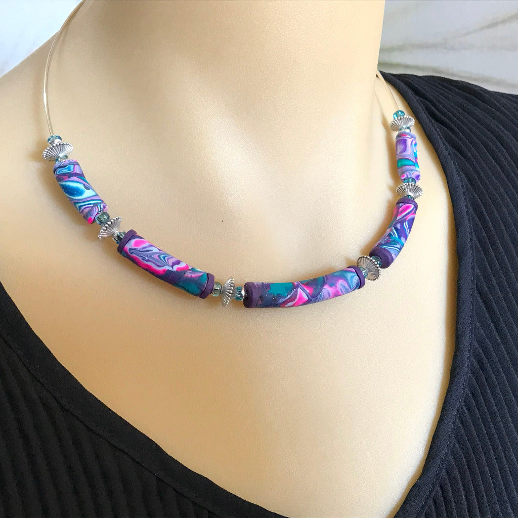 Handmade changeable necklace with curved polymer clay beads in purple, teal and pink marbled cosmic design, artisan jewellery Australia
