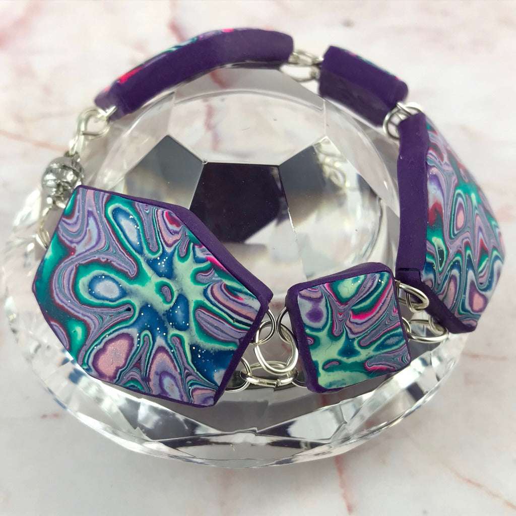 Handmade purple, teal and pink polymer clay bracelet with cosmic flower swirl pattern, artisan statement jewellery made in Australia