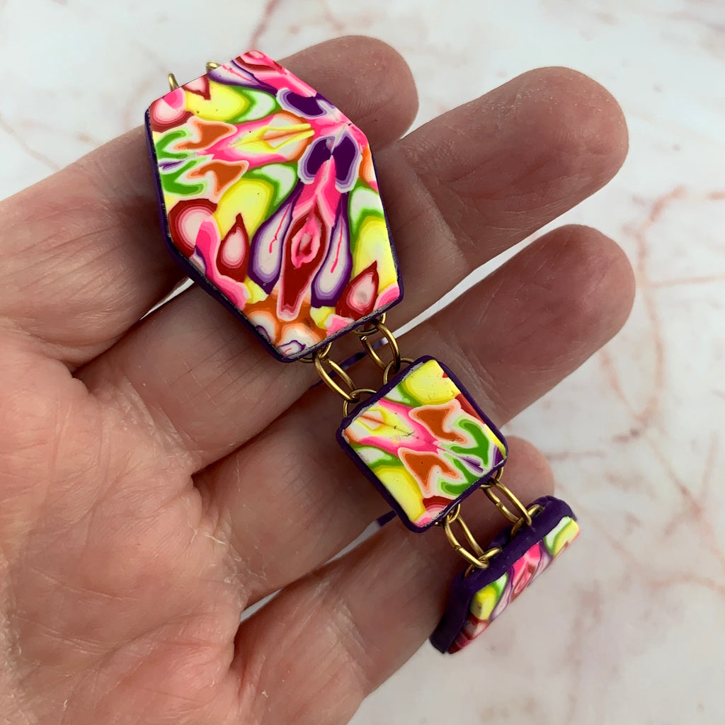 Close-up of handmade floral polymer clay bracelet showing vibrant pink, lime, purple, and white pattern detail by Rennique Australia.