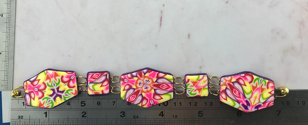 Handmade floral polymer clay bracelet shown with ruler for size reference by Rennique Australia.
