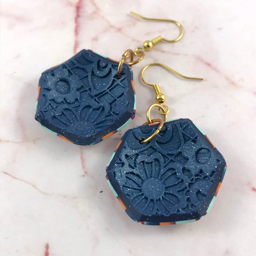 Back view of handmade polymer clay geometric drop earrings featuring smooth navy backing, gold hook connectors and artisan craftsmanship detail.