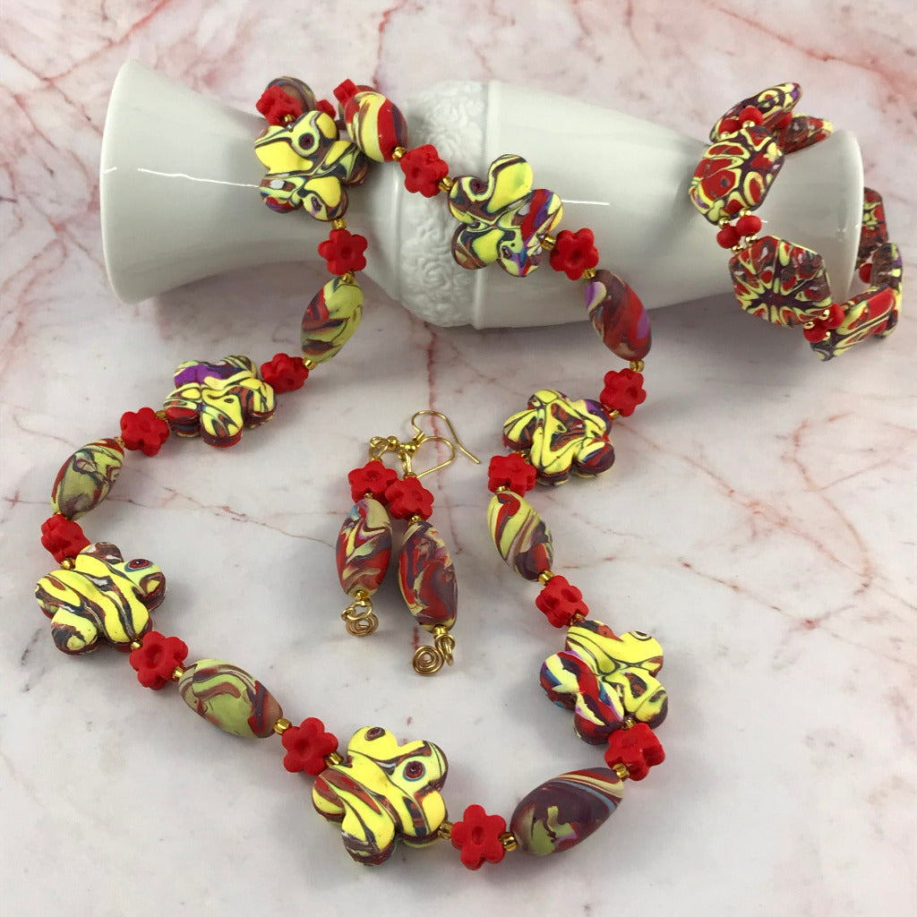 Handmade red and yellow polymer clay jewellery set hero image featuring necklace bracelet and earrings