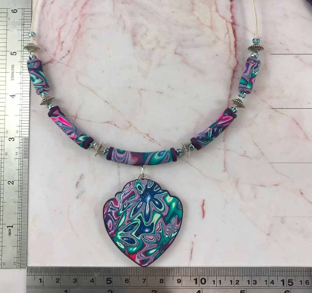 Handmade heart pendant necklace with purple teal and pink cosmic swirl marbled polymer clay on silver neck wire, artisan jewellery Australia