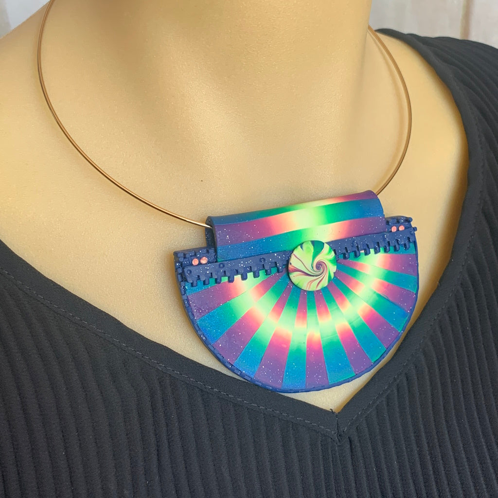 Shows the pendant on a metal neck ring as it would look being worn. Shown on a model.