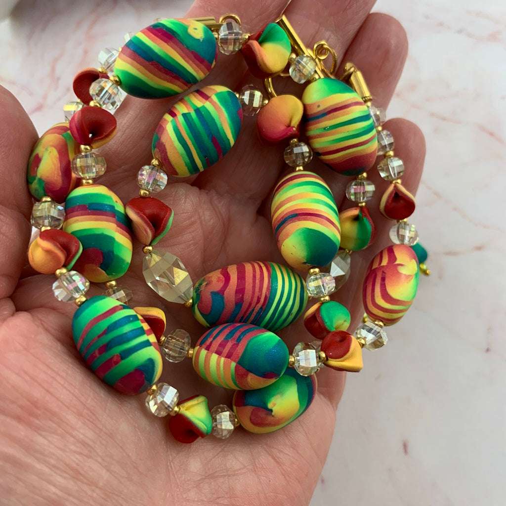 necklace with vivid coloured polymer clay beeds spaced with crystal beads.