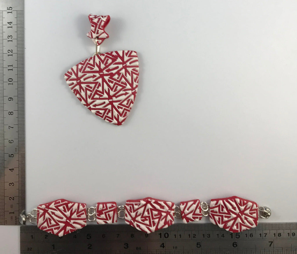 Pendant and bracelet measurement image with ruler showing size and curved design details.