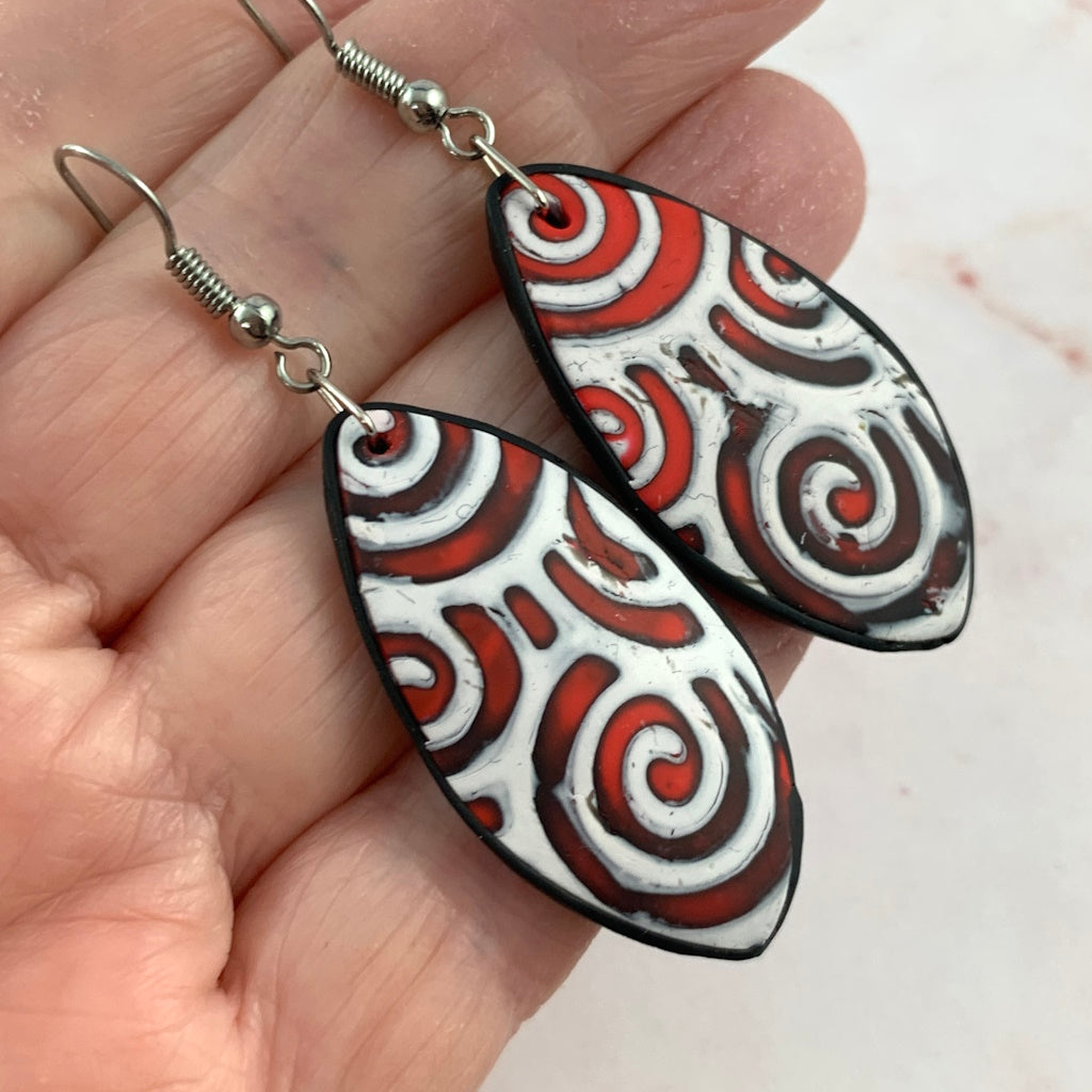 Boho red swirl dangle earrings with black trim and silver fish hook