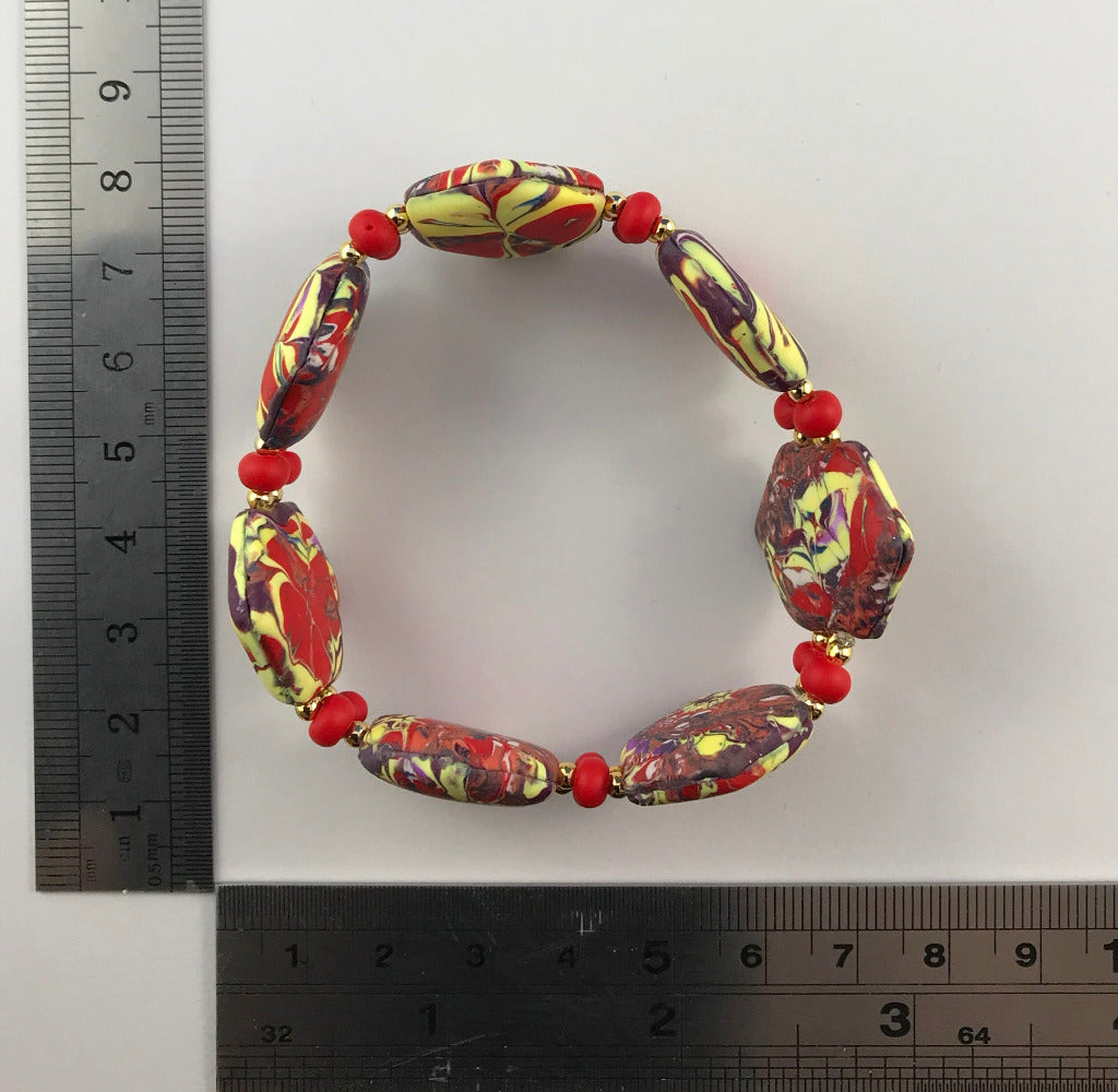 Handmade red and yellow polymer clay stretch bracelet with marbled artisan beads and floral accents