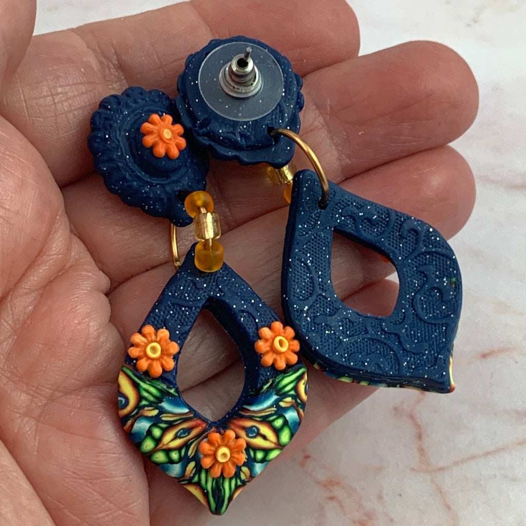 Award-winning Rennique hand-sculpted designer earrings showing front floral detail and embossed blue textured back finish.