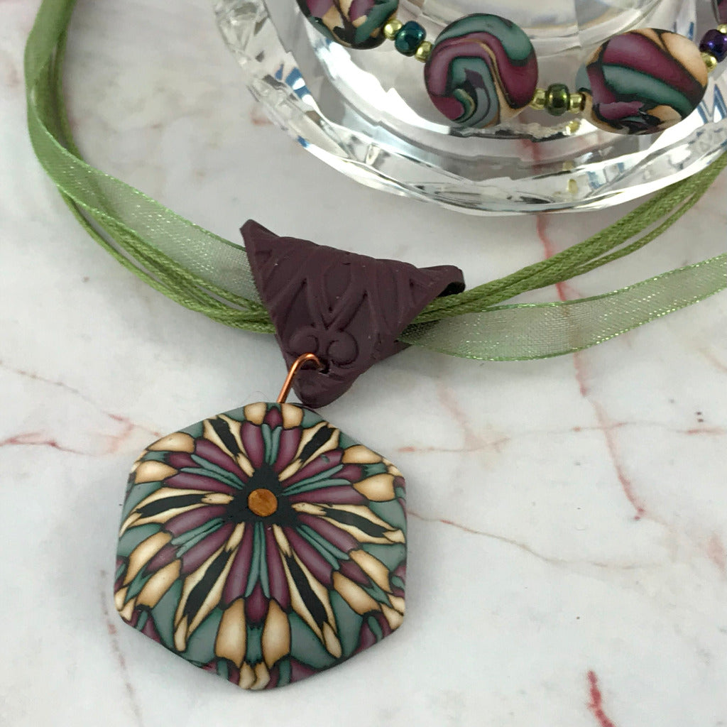 Rennique artisan geometric polymer clay earrings featuring muted deep red floral abstract design with curved lightweight statement shape