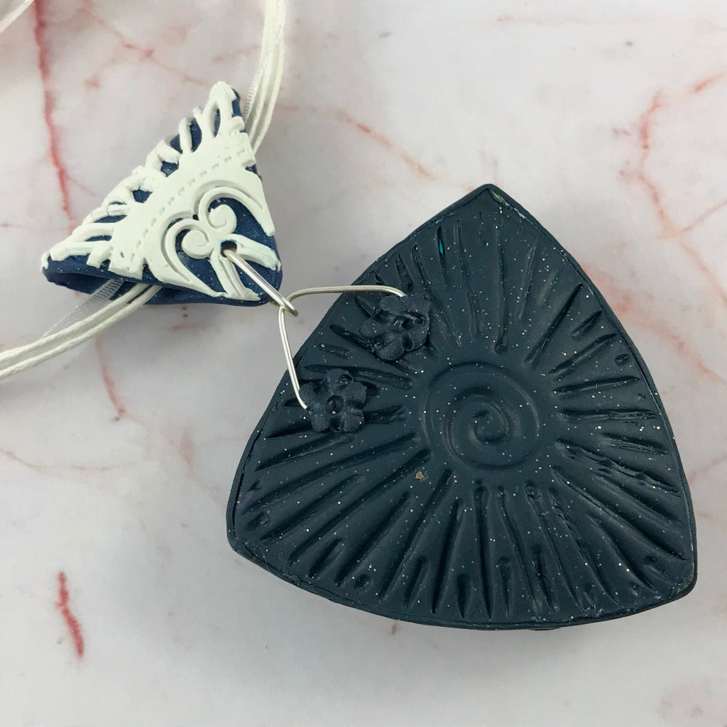 Back view of bold blue and white abstract feature pendant with polymer clay finish.