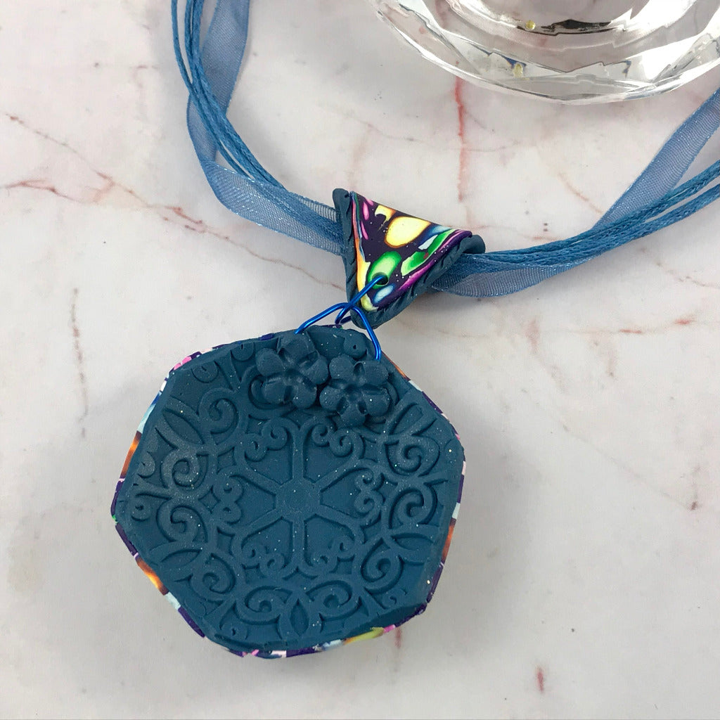 Back view of Rennique bold floral hanging pendant with textured embossed artisan finish and floral detailing