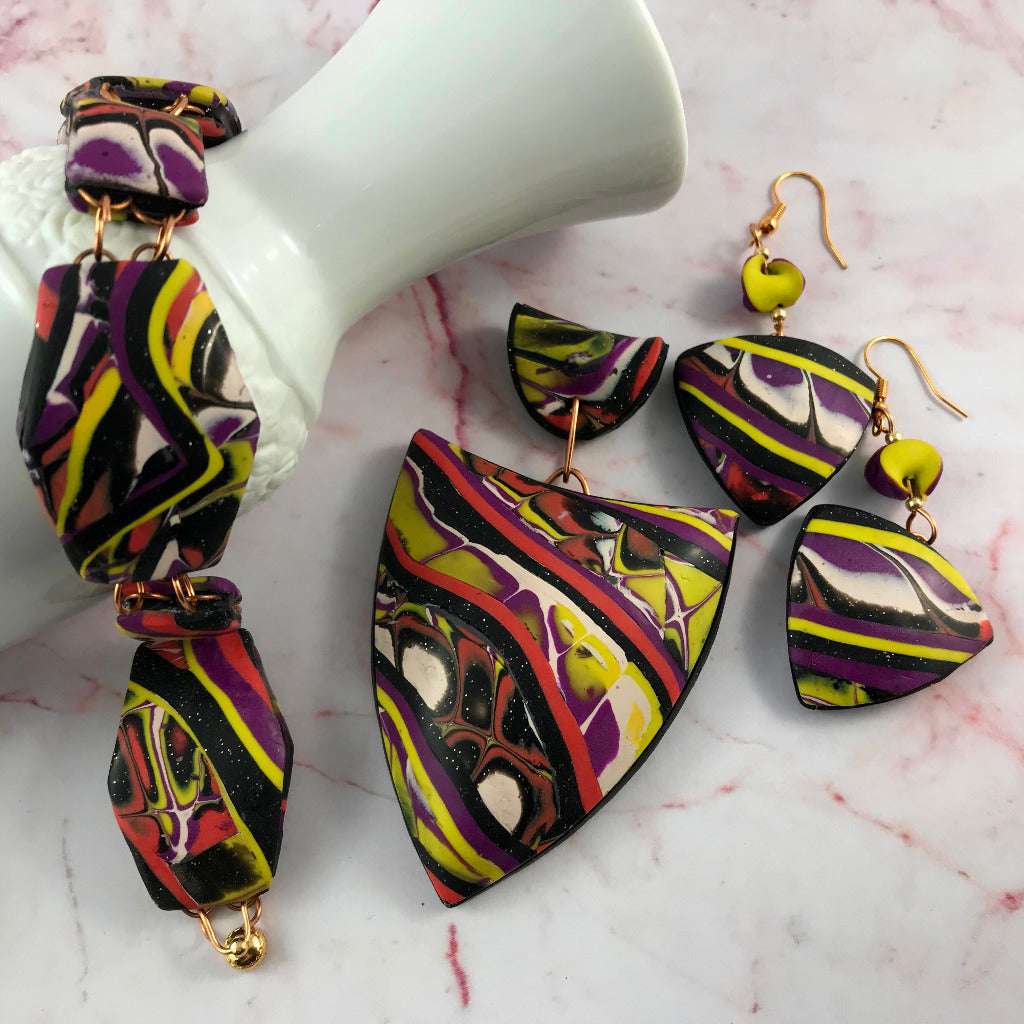 Featured image of bold abstract patchwork pendant, earrings, and bracelet handmade polymer clay jewellery set.