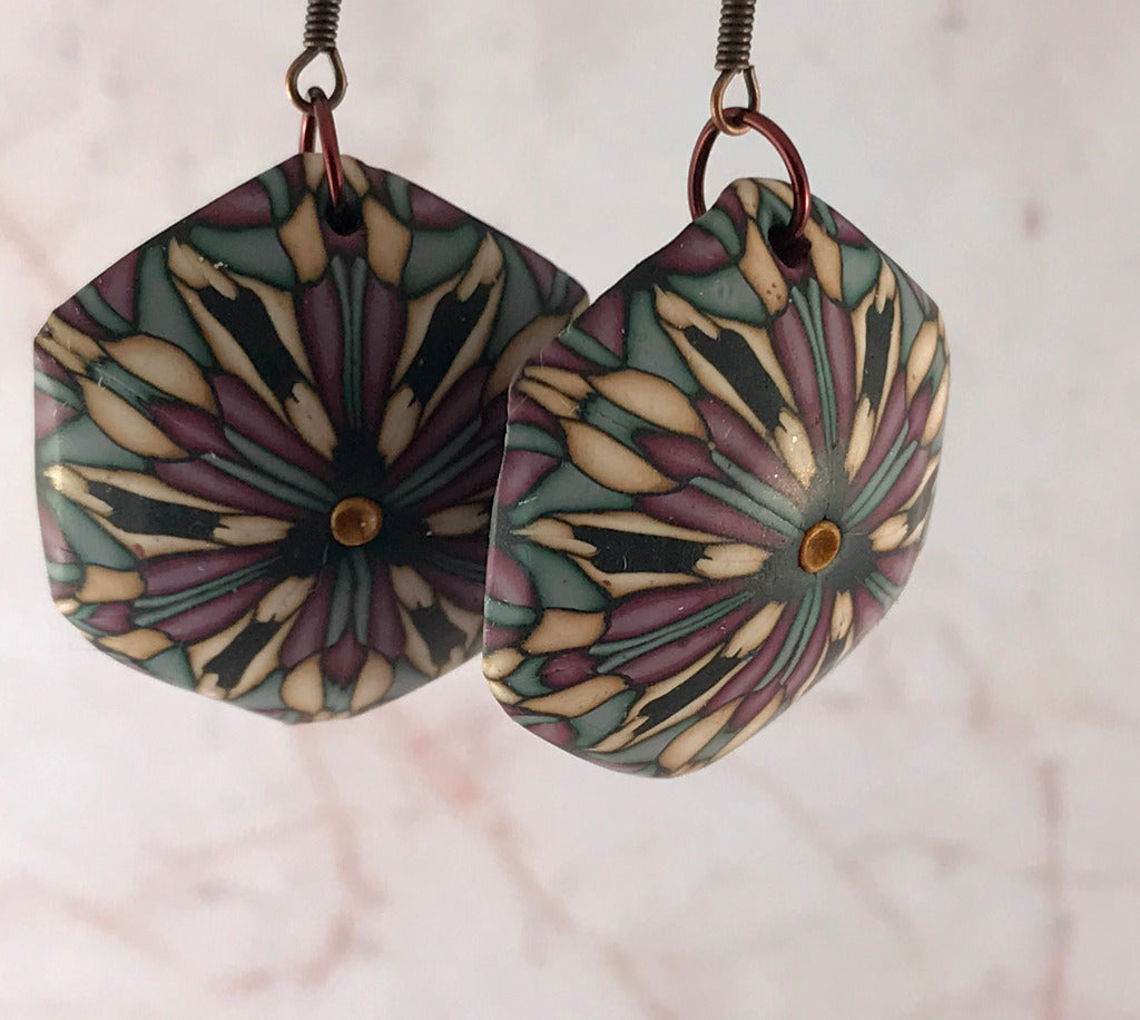 Rennique handmade geometric statement bracelet in deep red and muted complementary tones shown with measurement guide, artisan polymer clay jewellery