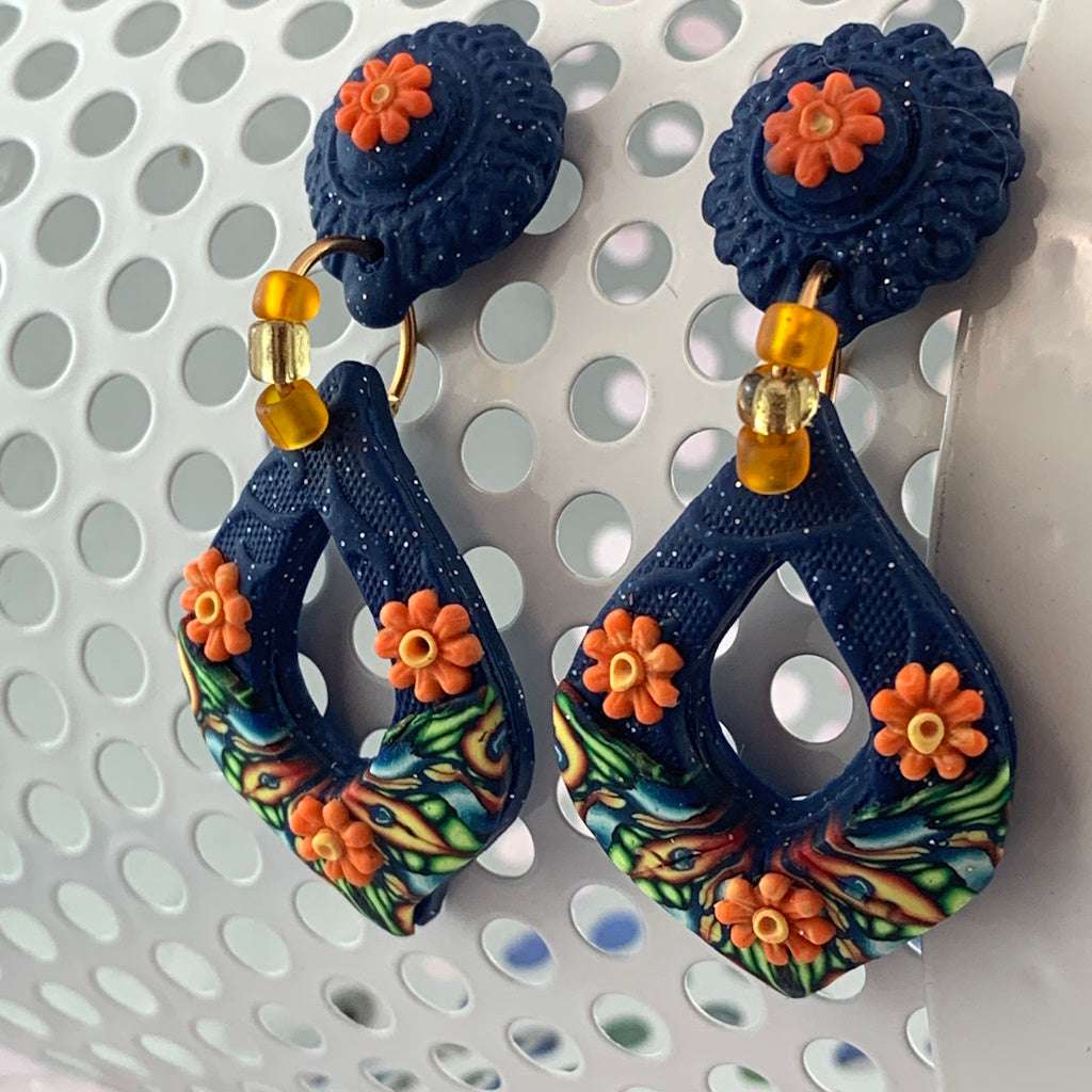 Award-winning Rennique handmade blue teardrop statement earrings with orange flowers, gold beads and embossed artisan finish front view.