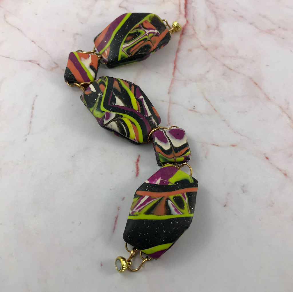 Handmade abstract patchwork bracelet with magnetic clasp in bold polymer clay design.