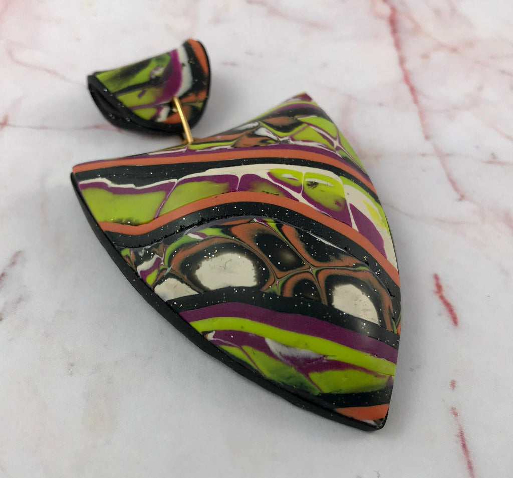 Front view of bold patchwork polymer clay pendant with wearable art collage design.