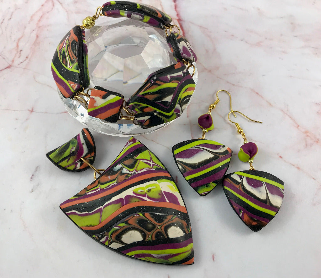 Bold abstract patchwork polymer clay jewellery set with pendant, bracelet, and matching earrings.