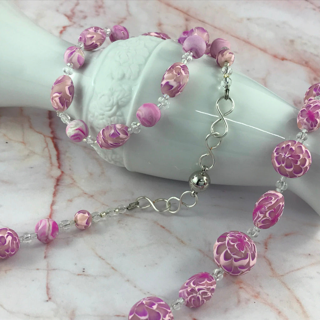 Feature image of pink floral polymer clay necklace, matching earrings, and bracelet jewellery set.