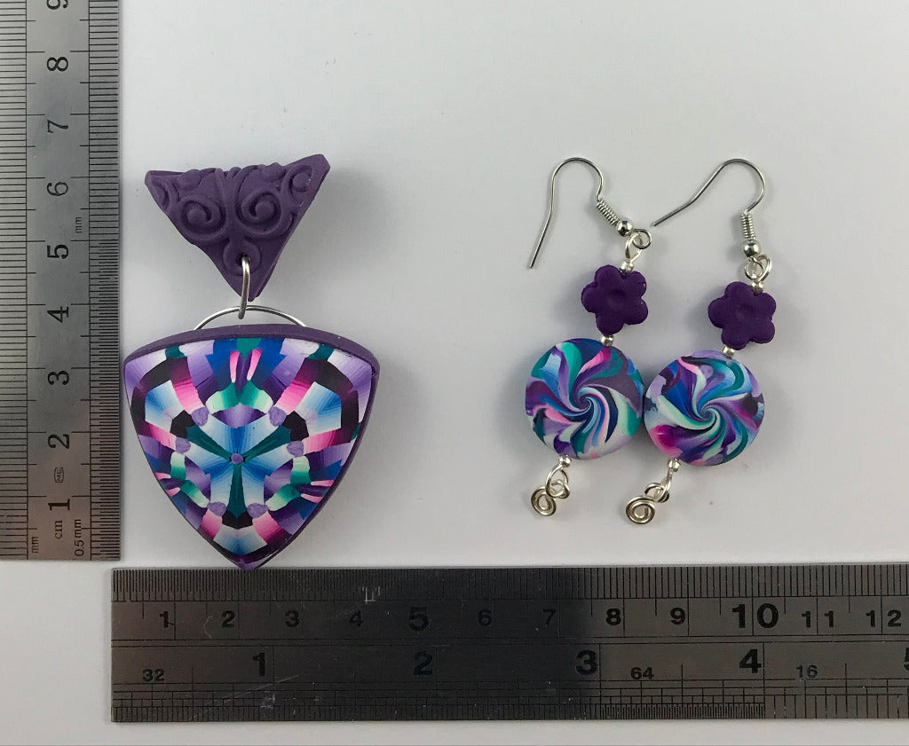 Pink and purple pendant necklace and matching earrings displayed with ruler for size measurement.