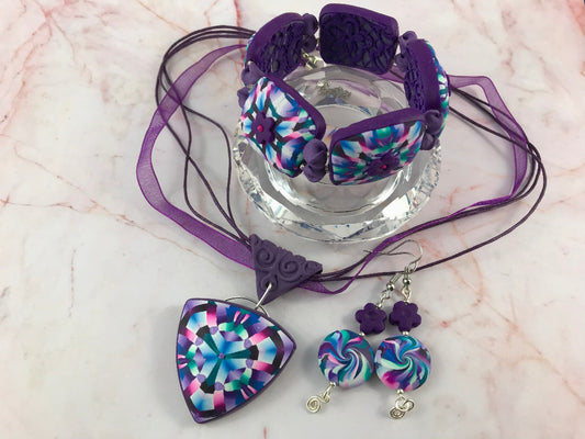 Rennique Accessories pink and purple handmade polymer clay jewellery set featuring statement pendant necklace, matching bracelet, and earrings.