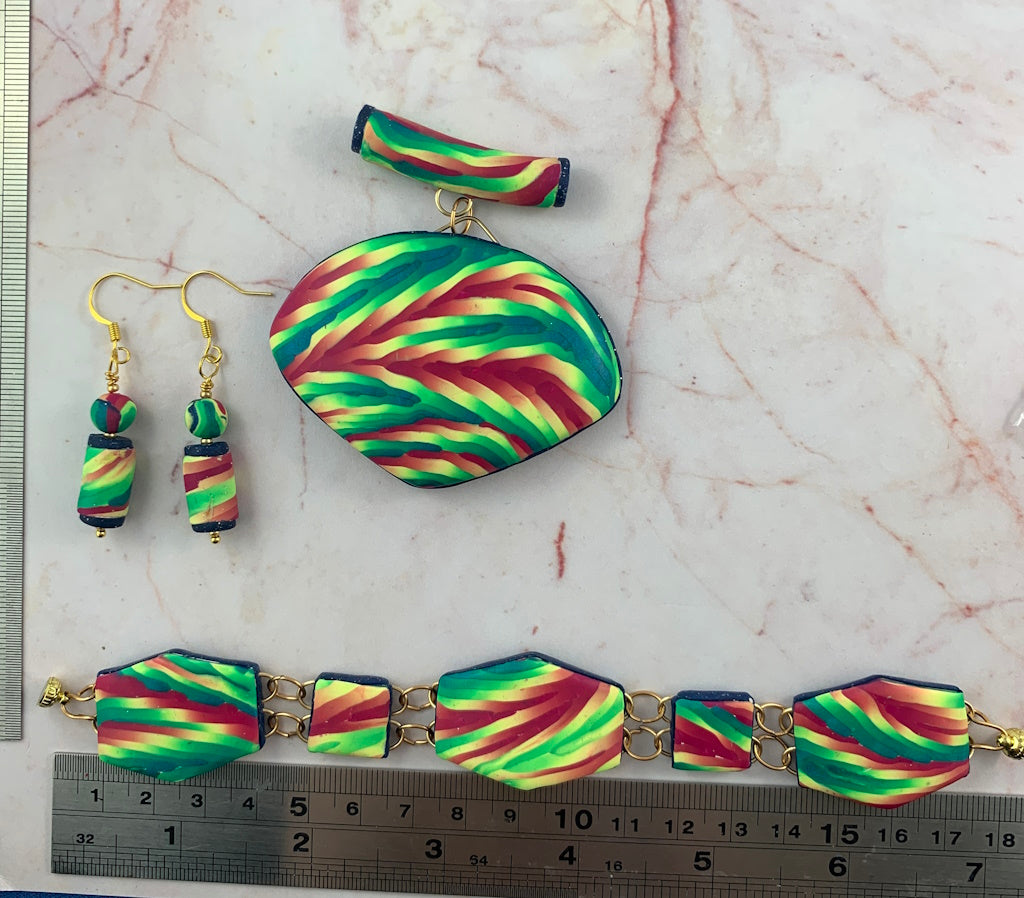 Rennique handmade multicolour statement jewellery set featuring matching pendant necklace, drop earrings and linked bracelet in vibrant green, pink and teal striped polymer clay design.