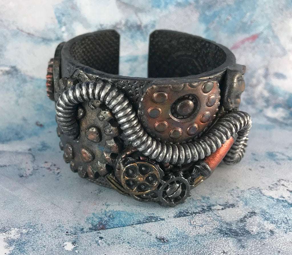 Statement steampunk cuff bracelet by Rennique Studio, one-of-a-kind wearable art with mechanical elements, gears, and metallic finishes.