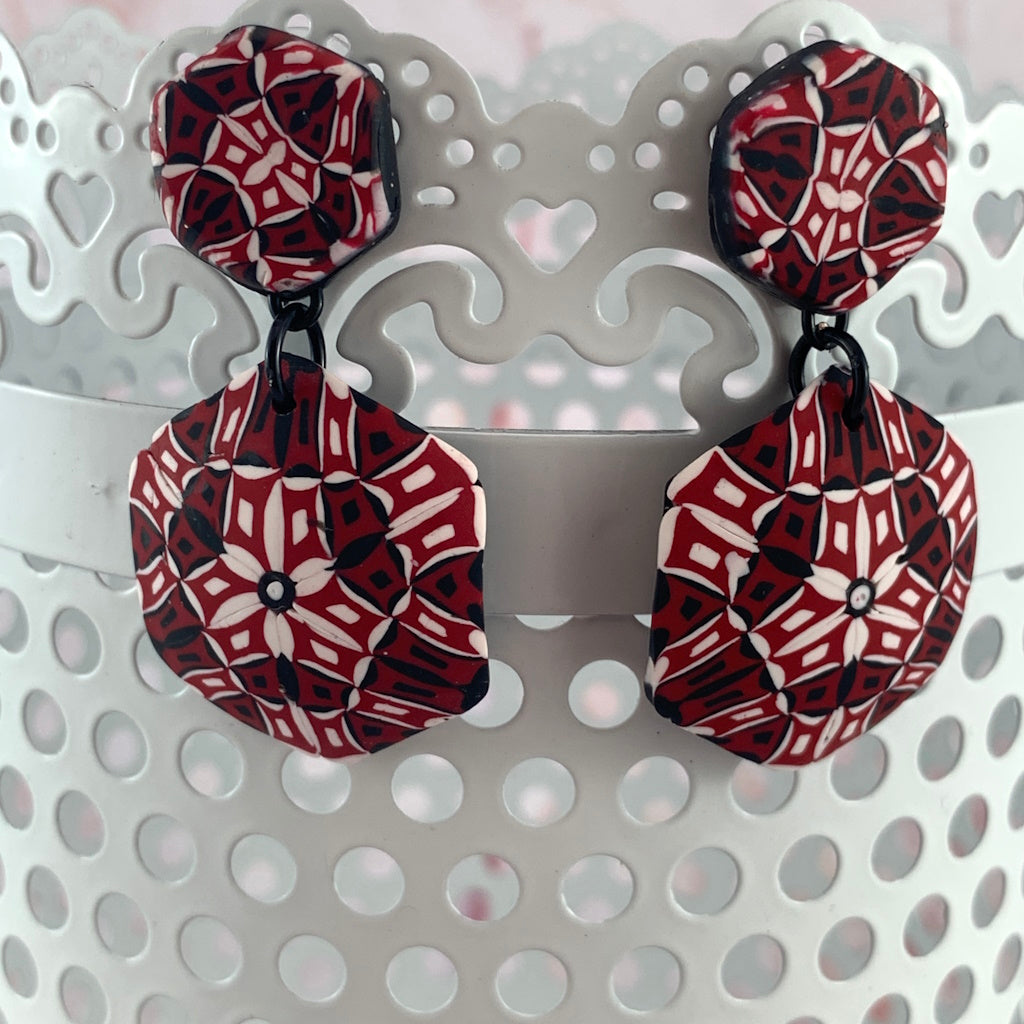 Rennique Studio one-of-a-kind wearable art polymer clay drop earrings in bold red, black and white geometric kaleidoscope pattern.