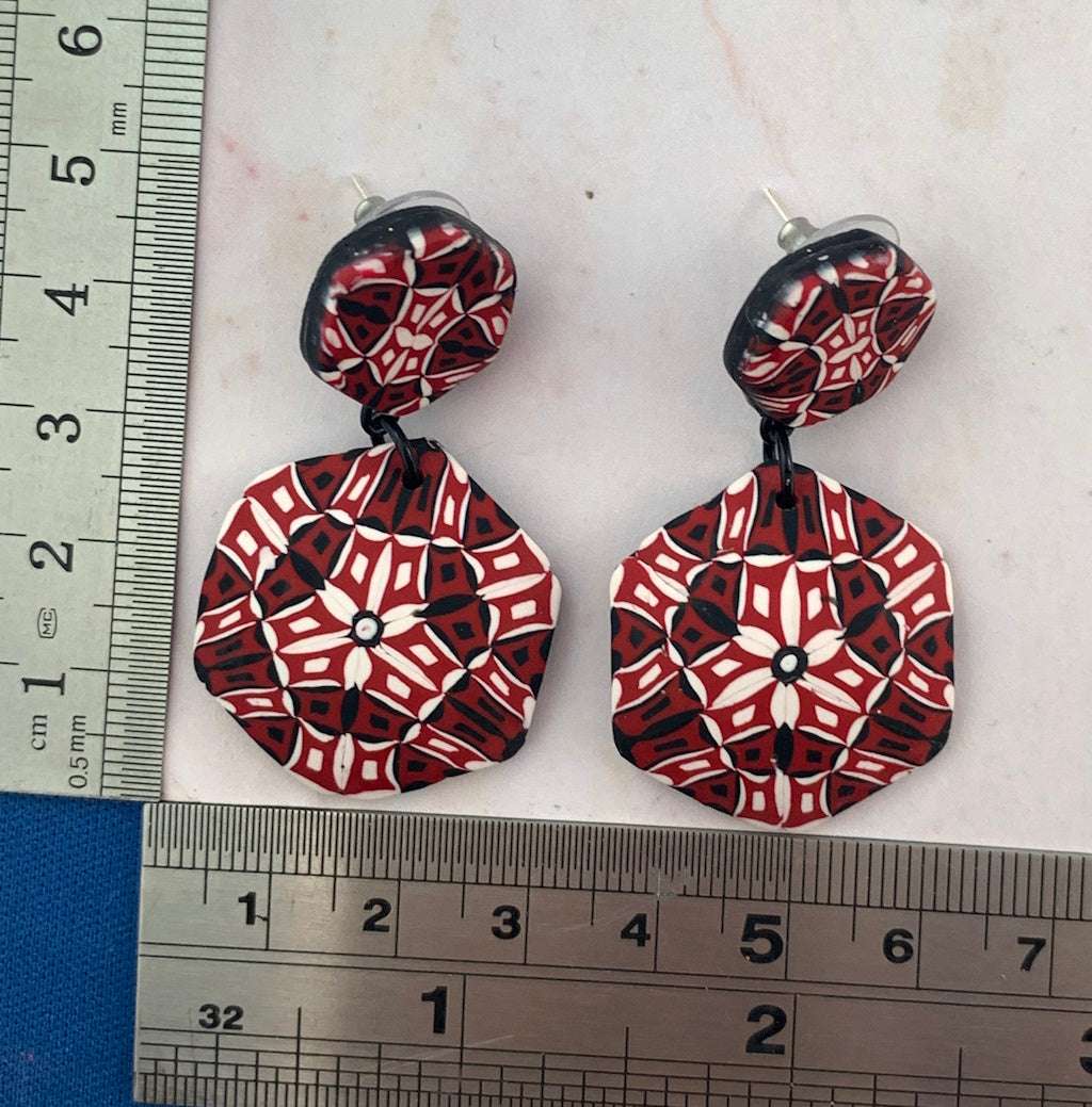 Rennique Studio one-of-a-kind wearable art polymer clay statement earrings in bold red, black and white geometric design with size reference.