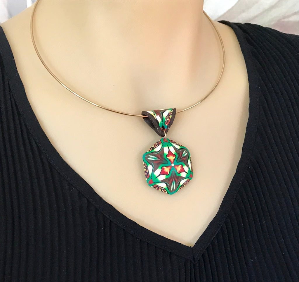 Rennique tropical-themed statement pendant necklace worn on model, handcrafted polymer clay jewellery in green, black, cream, and orange.