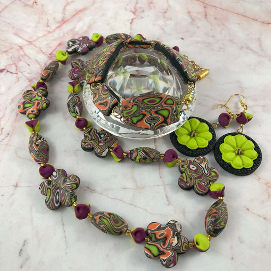 Complete handmade jewellery set displayed around crystal stand featuring necklace, bracelet and matching earrings in ripple autumn tones.