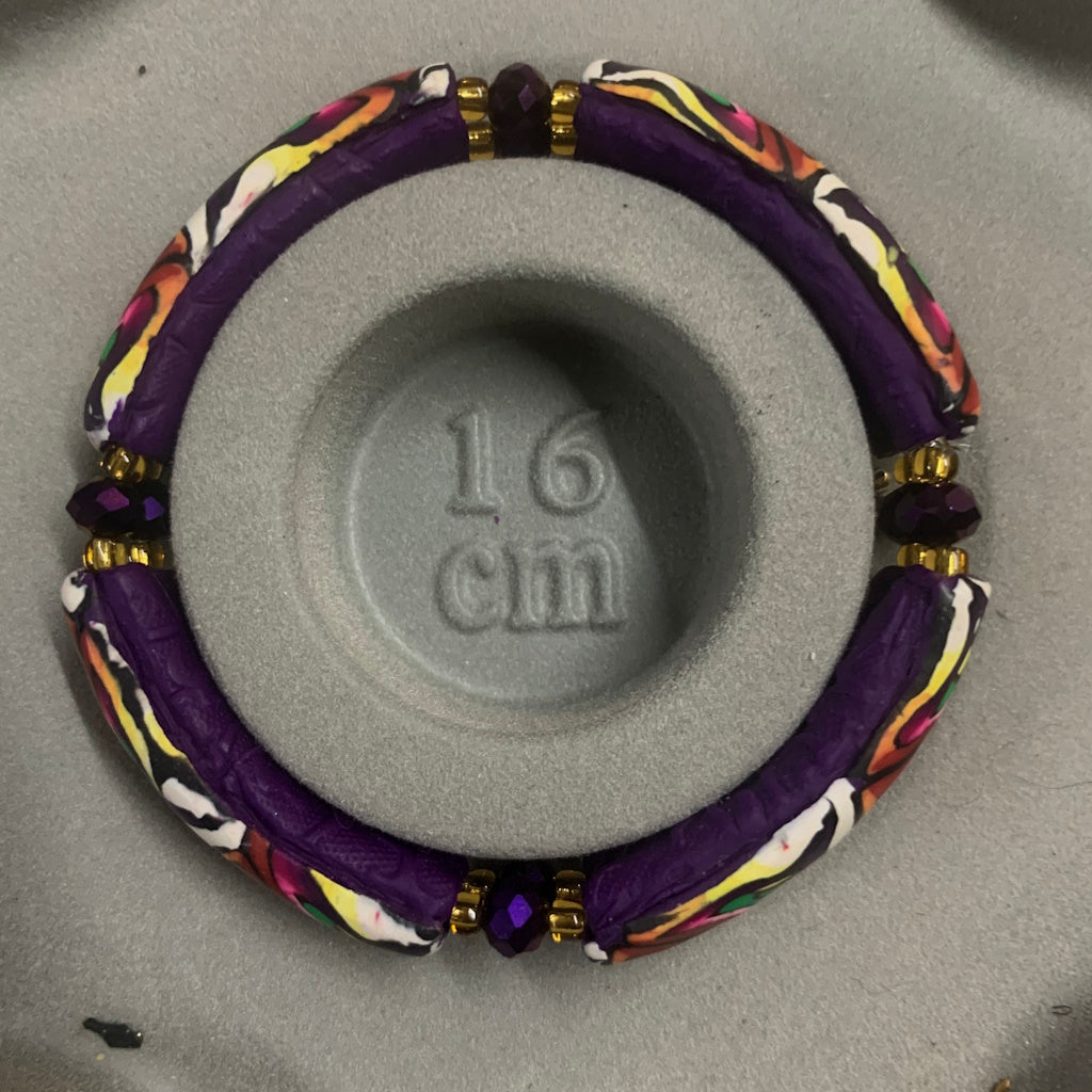 Handmade 16cm stretch bracelet featuring abstract spring colours, deep plum backing and purple crystal spacer beads.