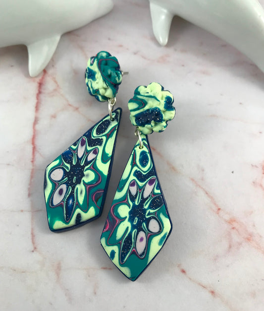Handmade teal, mint and navy blue polymer clay drop earrings with floral textured stud tops and geometric dangle design.