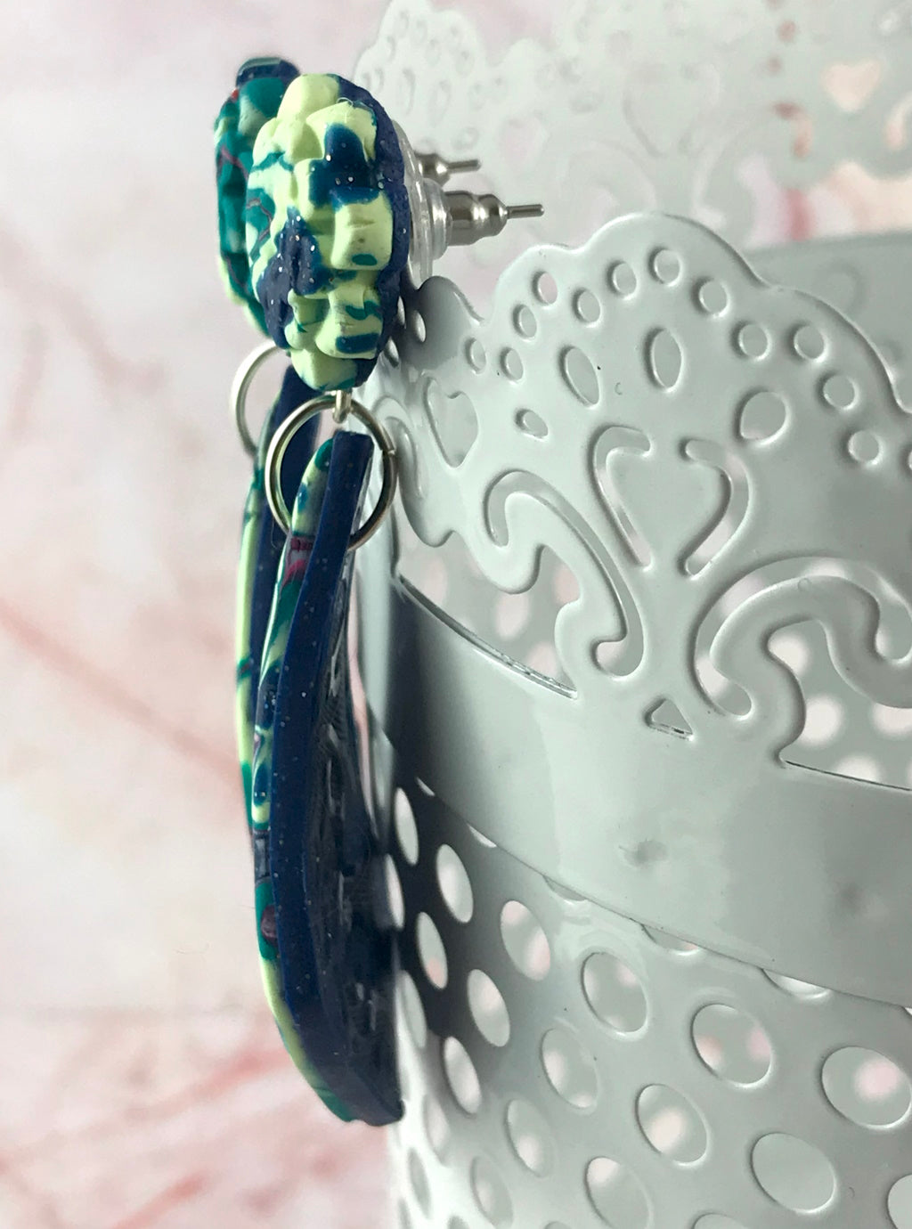 Side profile view of handmade polymer clay drop earrings showing thickness and layered design.