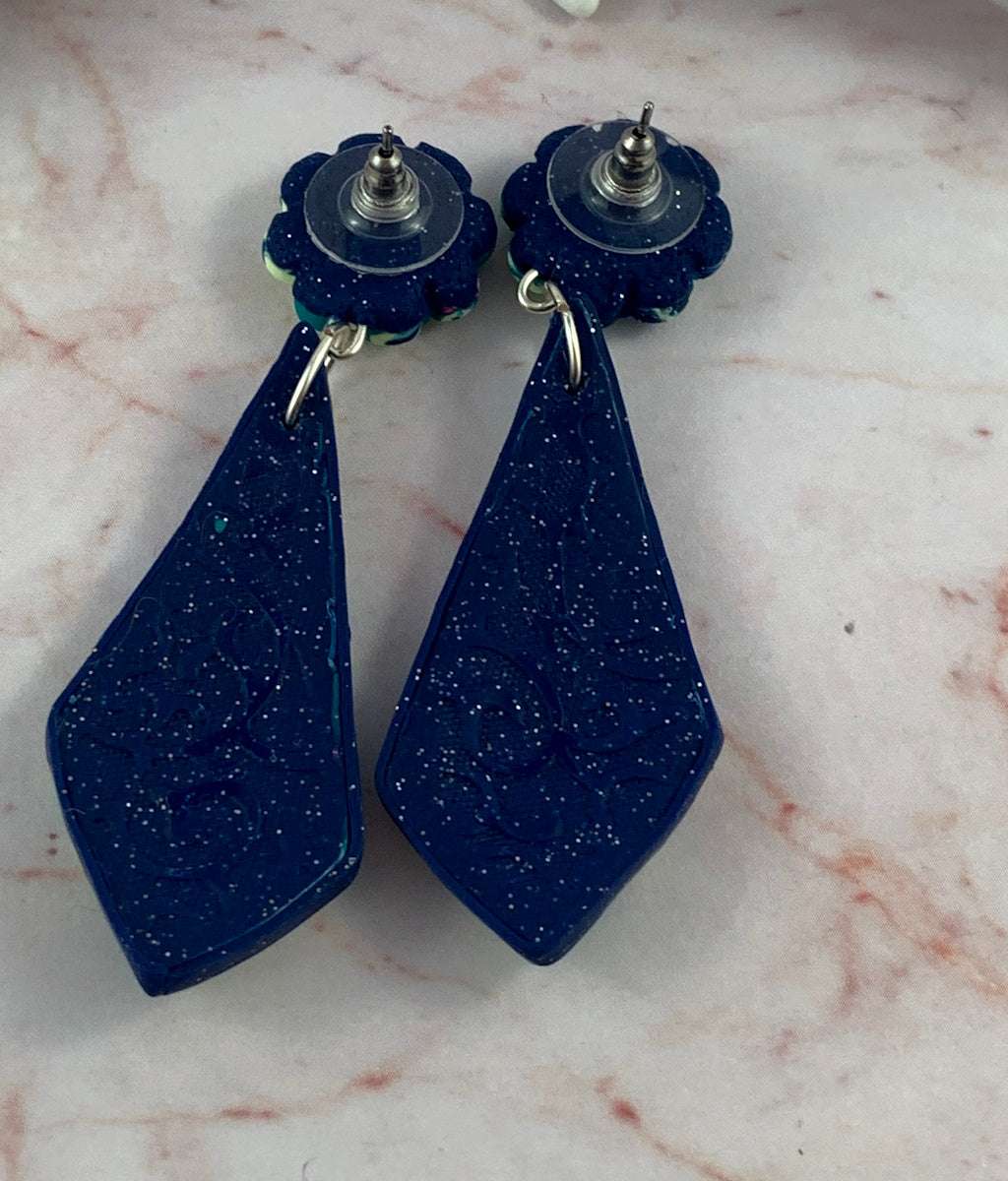 Back view of navy blue polymer clay earrings with subtle textured artisan finish and stud posts.