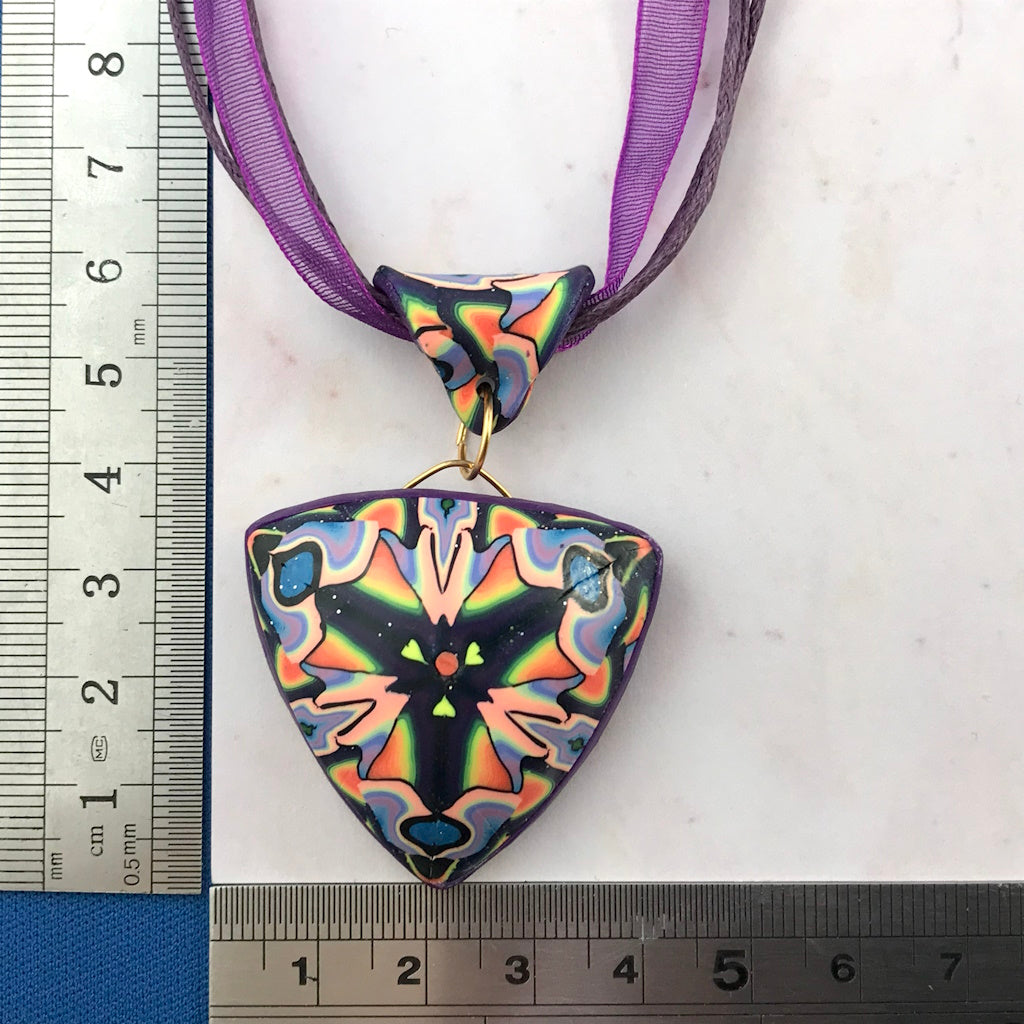 Handmade triangular polymer clay pendant necklace shown with ruler for size reference by Rennique Australia.