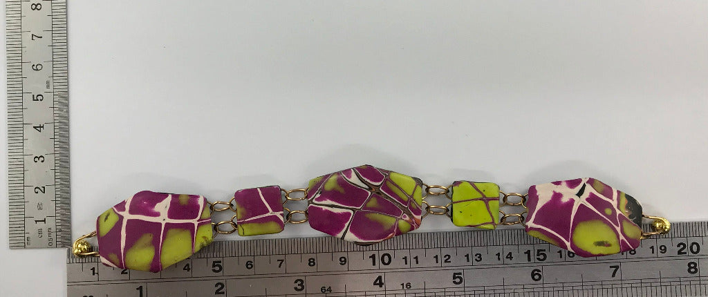 Unique yellow and purple polymer clay bracelet with magnetic clasp shown next to ruler for measurement.
