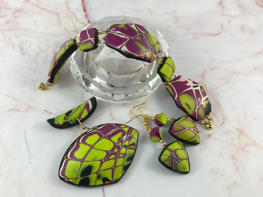 Side view of yellow and purple handmade jewellery set arranged on glass display.